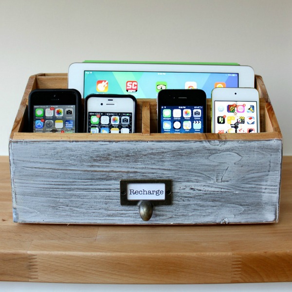 4 phones and 1 tablet placed in a wooden box