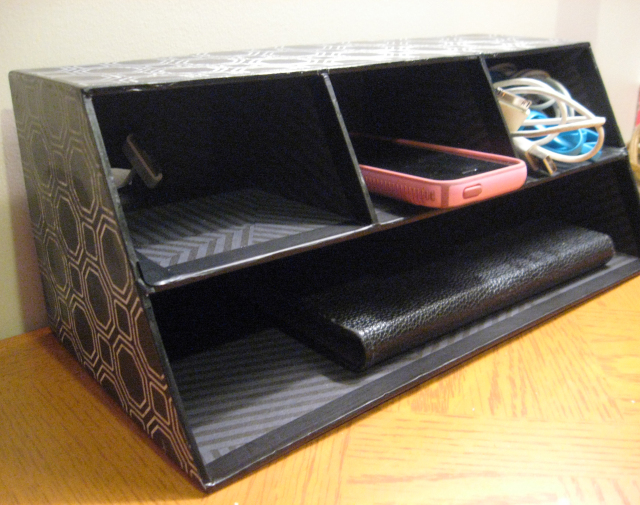 desk organizer turned charging station with a phone inside, a wallet and an earphone