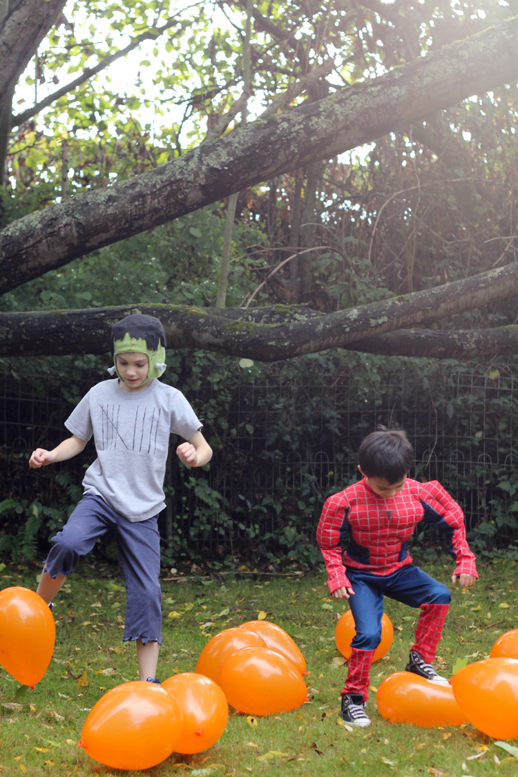 kids stomping on water filled balloons in the pumpkin patch stomping Halloween game