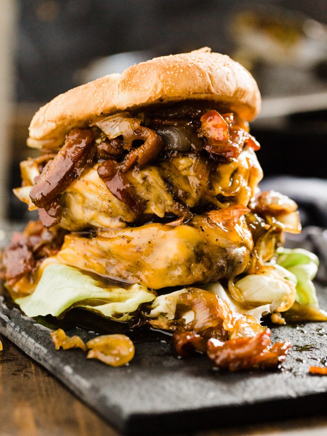 sloppy double-stacked caramelized onion and bacon Whiskey BBQ burger on a tray