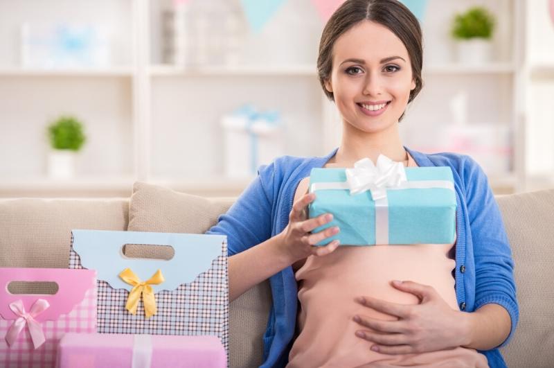 mom-to-be with a pile of presents at a a themed baby shower