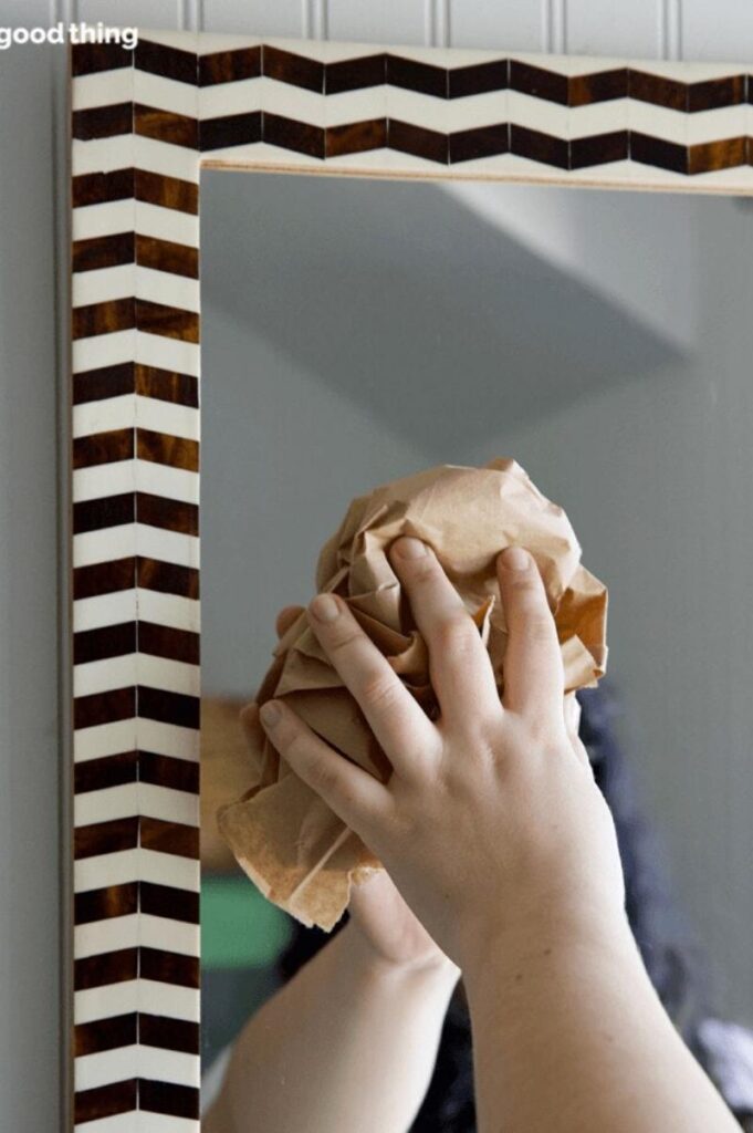 woman using a paper bags for washing mirrors