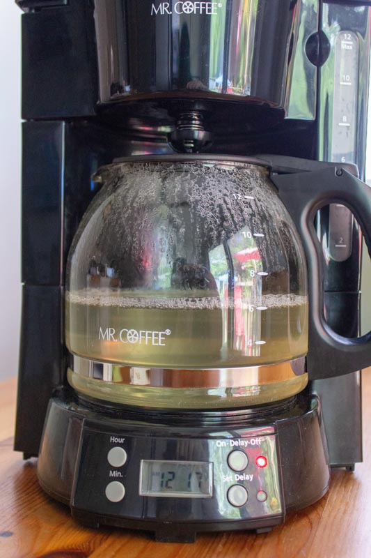 Coffee maker with vinegar being cleaned