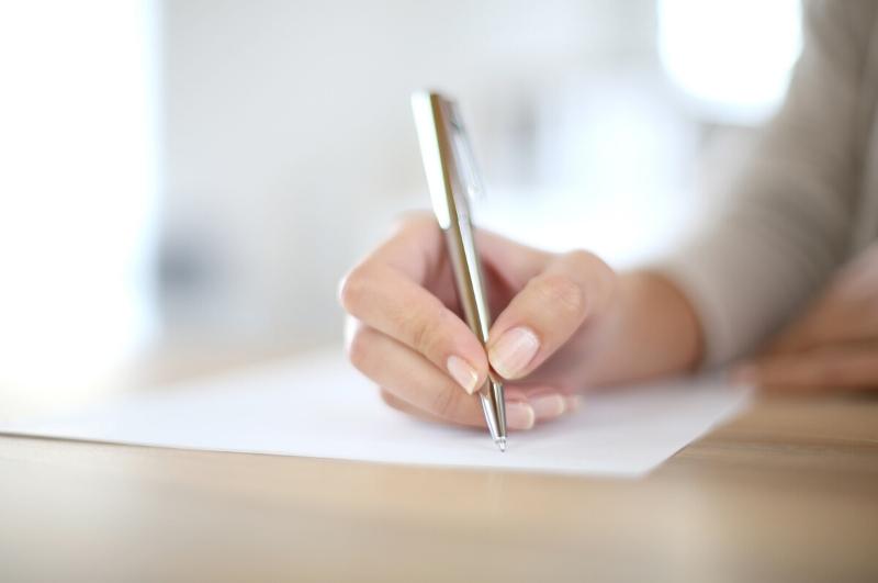 woman writing down a to do list on paper