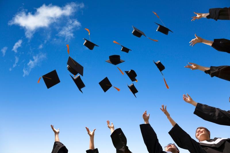 graduates throwing their caps into the air