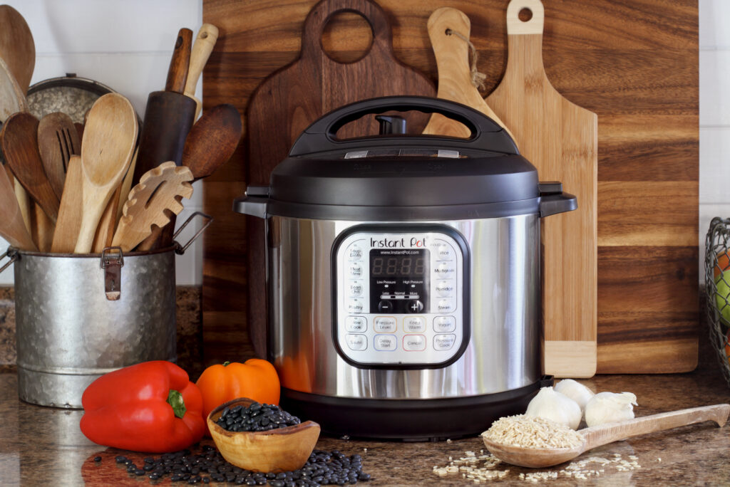 instant pot on a counter with peppers, rice and garlic