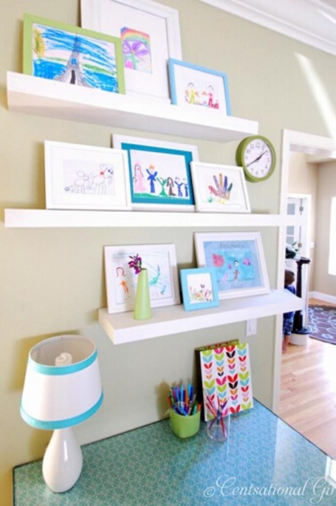 shelves holding frames with children's artwork in them