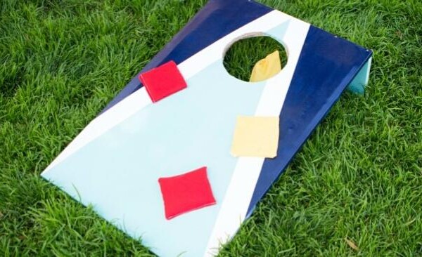 DIY cornhole board on the grass with bean bags on it