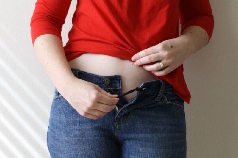 woman demonstrating how to use a DIY pants extender