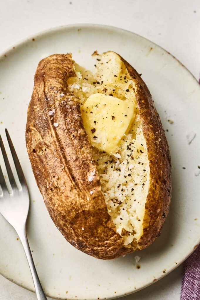 baked potato on a plate with a pat of butter