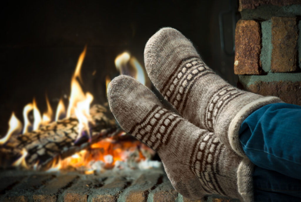 feet in heavy winter socks in front of a fire