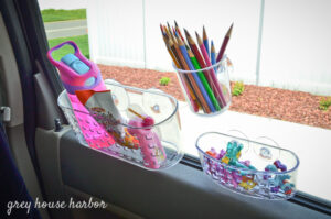 3 suction cup caddies on a car window with art supplies