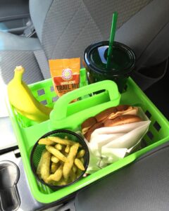 Green shower caddy on a road trip filled with food