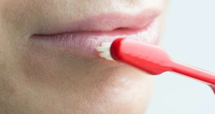 Exfoliate chapped lips using a toothbrush