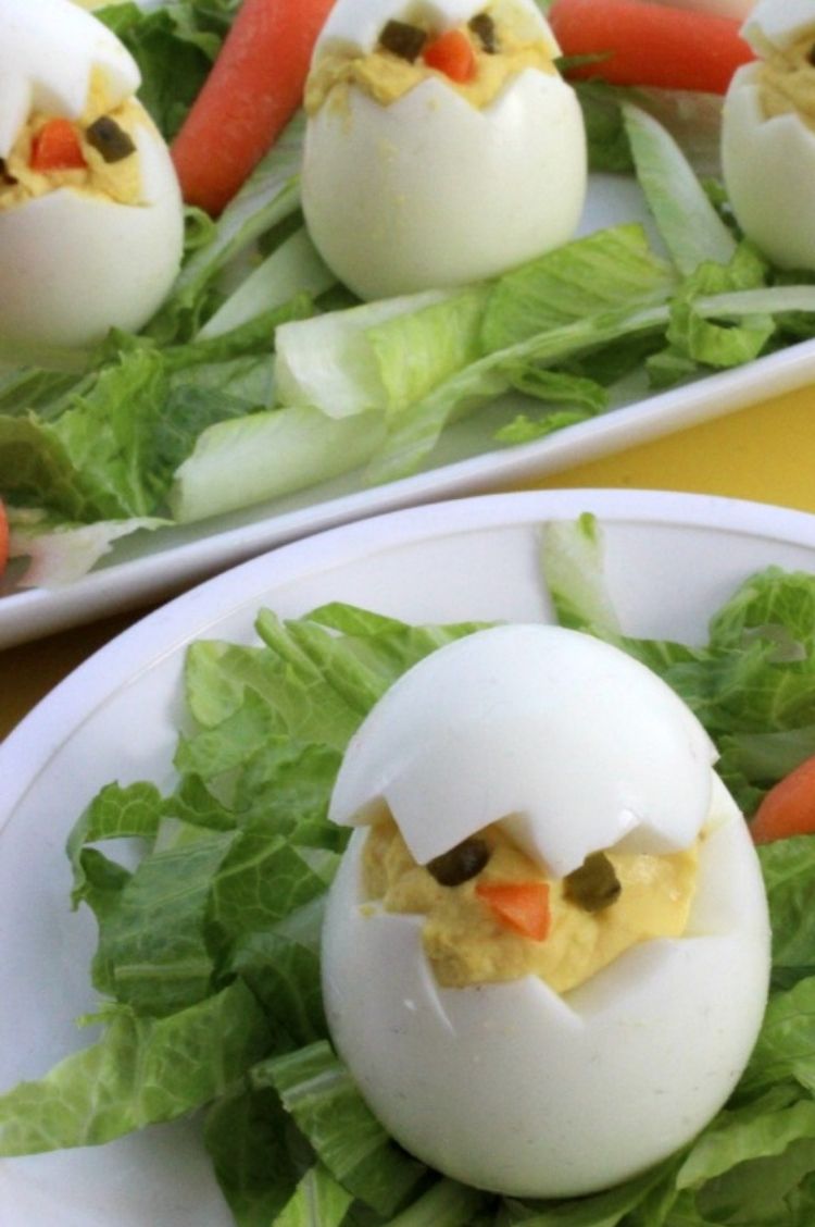 Deviled eggs cut in half and filled to look like a cracked egg, use small edible pieces of carrots or peppers to make faces inside the filling