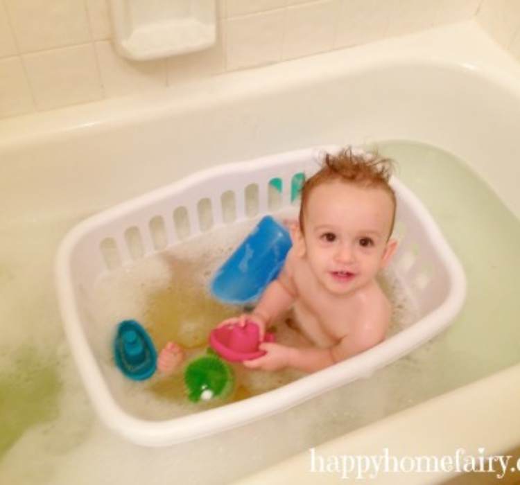 Picture of baby in a laundry basket which is in the big tub