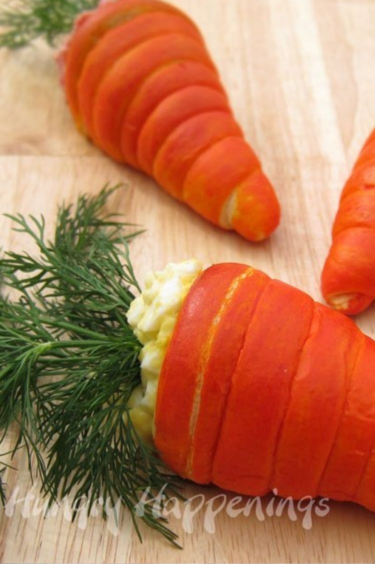 Crescent rolls dyed orange and wrapped around to form the look of a carrot, stuffed with egg salad