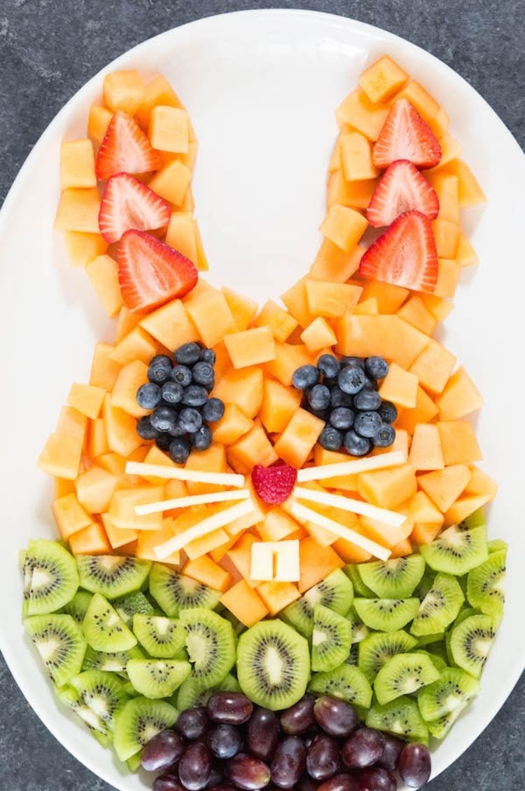 Easter party Fruit arranged in the shape of a Easter bunny face using strawberries, blueberries, cantaloupe, and kiwi