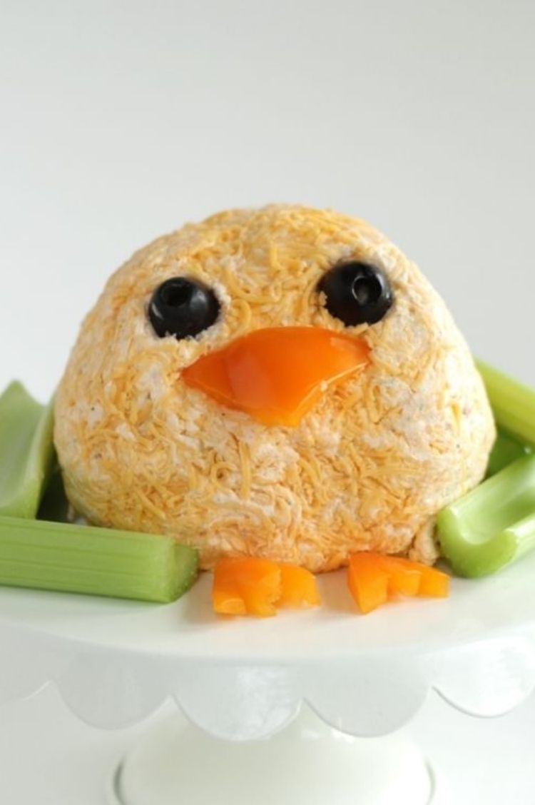 Edible cheese ball made into the shape of Easter Chick with olives for eyes and peppers cut into a beak and feet shapes