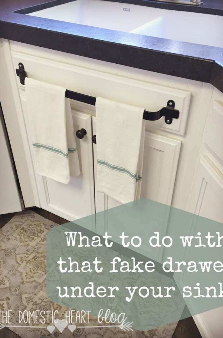 One Crazy House how to Organize Kitchen front of kitchen cabinets with towel rod added to fake drawer in front of sink. Title card says "What to do with the fake drawer under your sink"