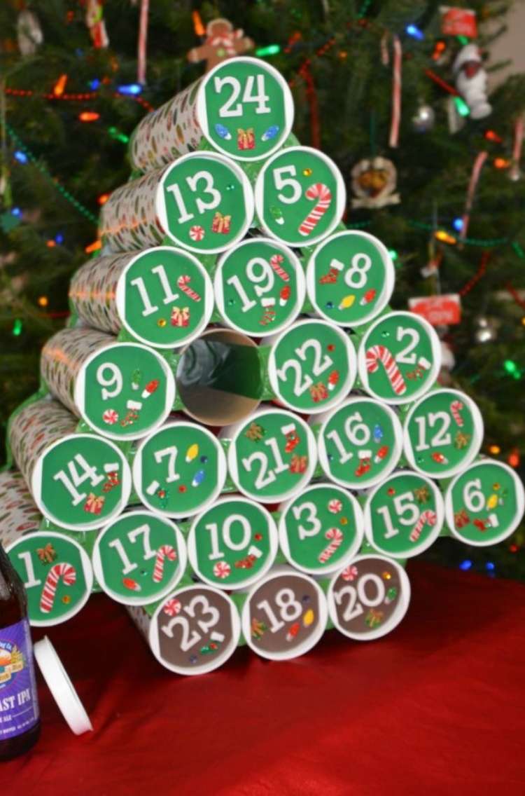 OneCrazyHouse Pringles Can Hacks Pringles cans painted and stacked in shape of chrismas trees with numbers on each lifd representing each door of an advent calendar with Christmas tree in background