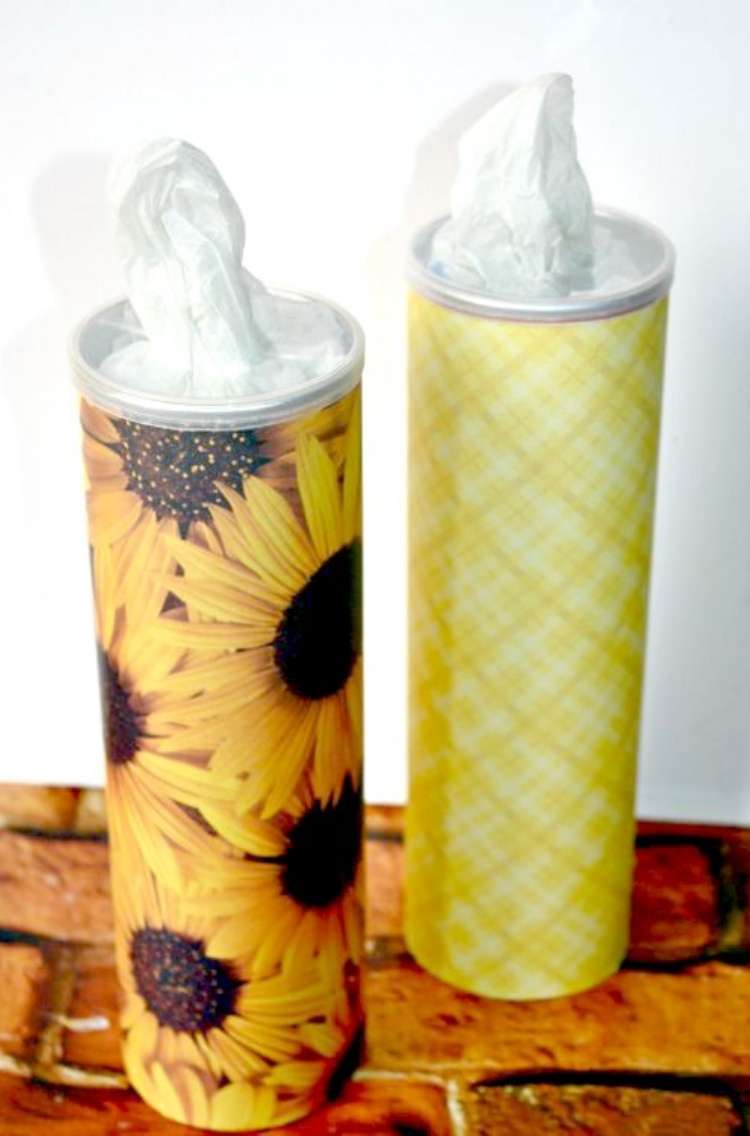 two pringles cans wrapped in decorative paper used as a paper towel dispenser