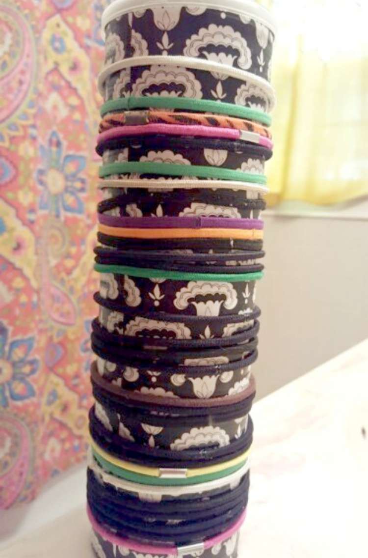 Hair ties wrapped around pringles can covered in patterned paper