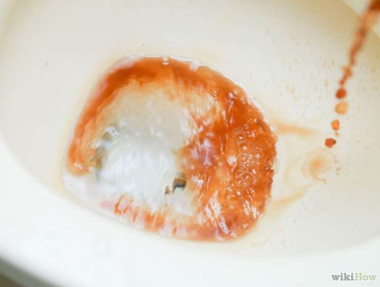 Coca cola being poured into toilet bowl