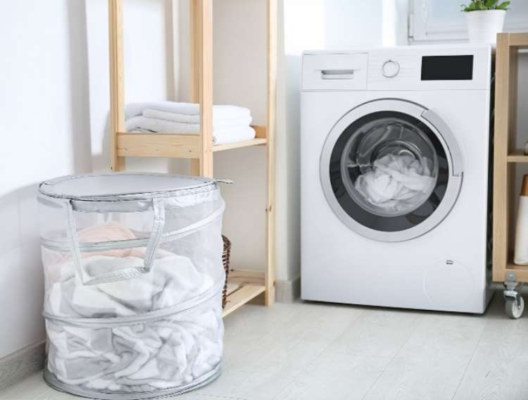 OneCrazyHouse recycled towels Laundry room with washer, hamper and shelving with folded towels on it.