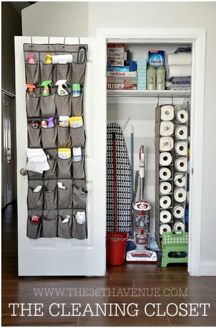 Open linen closet with shoe holder repurposed to hold cleaning supplies on the inside of the door and shoe holders hanging inside holding papertowels