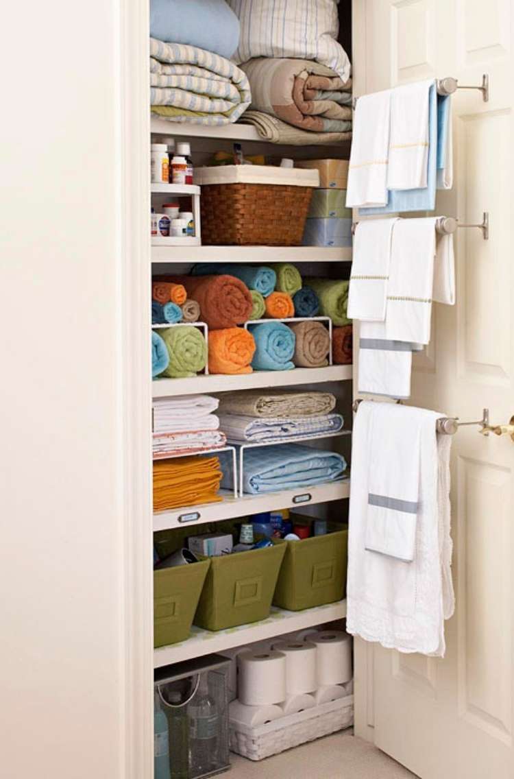 Onecrazyhouse Linen Closet Organization linen closet open to show neatly folded linens with towels hanging from towel racks attached to inside of the door