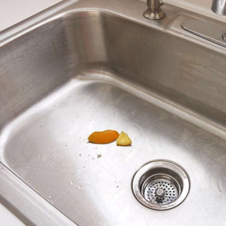 orange peel uses - 2 pieces of orange peel in a stainless steel sink