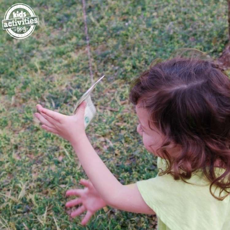 April fools prank, little girl chasing a floating dollar bill on a fishing line