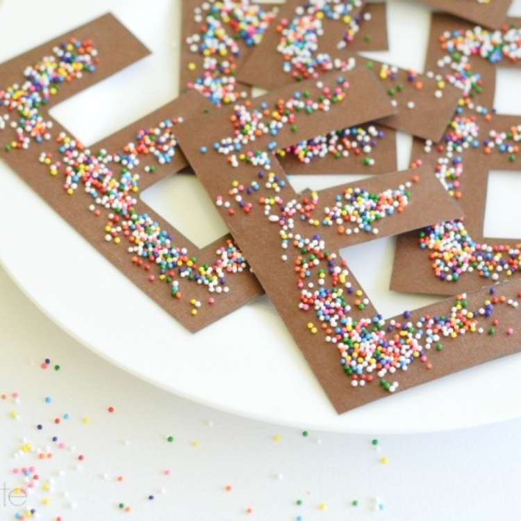 April fools trick, a plate full of paper cut outs of bown Es with candy sprinkles on top 