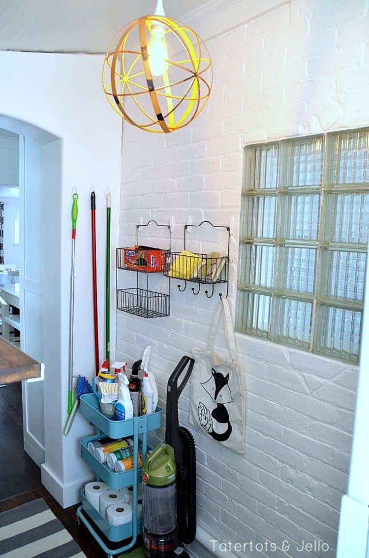 a cart on wheels with household cleaning tools and supplies