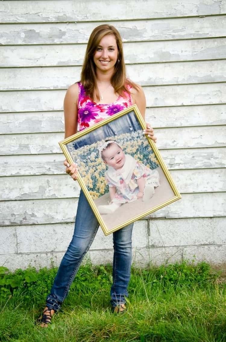 senior picture ideas for girls - girl posing while holding baby photo in front of her