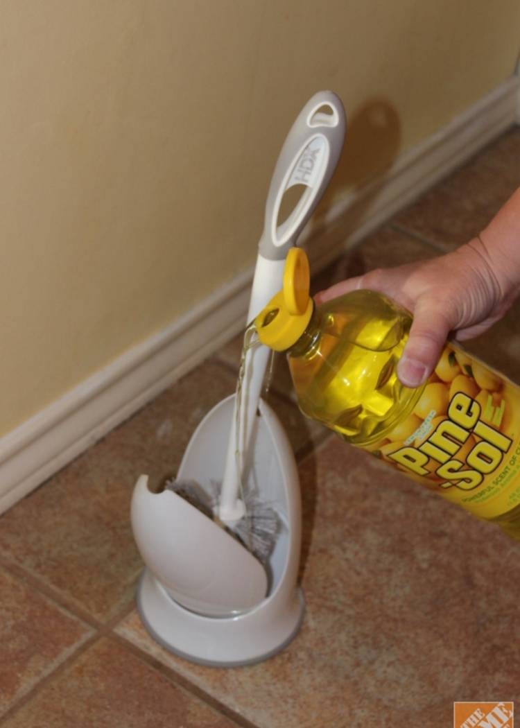 pouring disinfectant on a toilet bowl brush holder