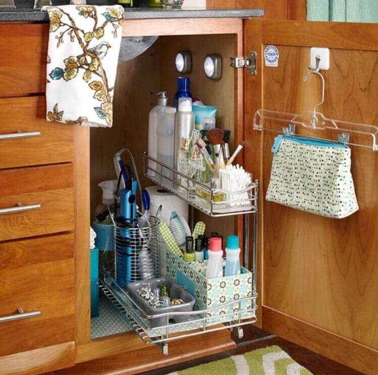 Under the sink storage ideas - a command hook holding a hanger with clips so the hanger can hold a cosmetic bag