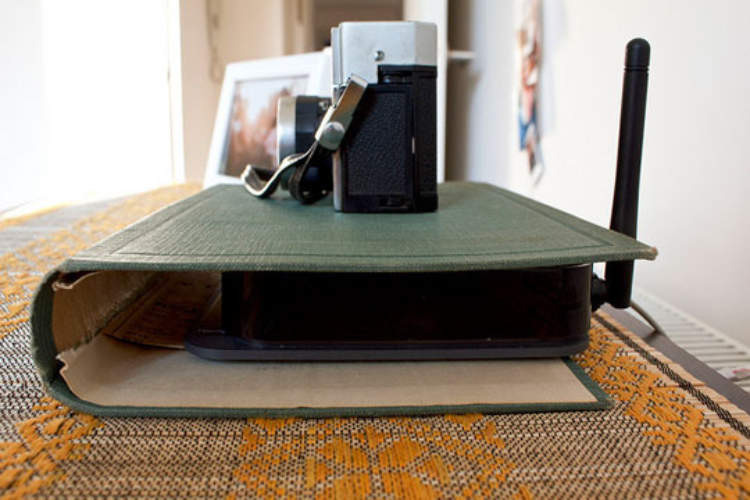 hHdden storage idea - a book cover being used to disguise a router and hide it from sight.