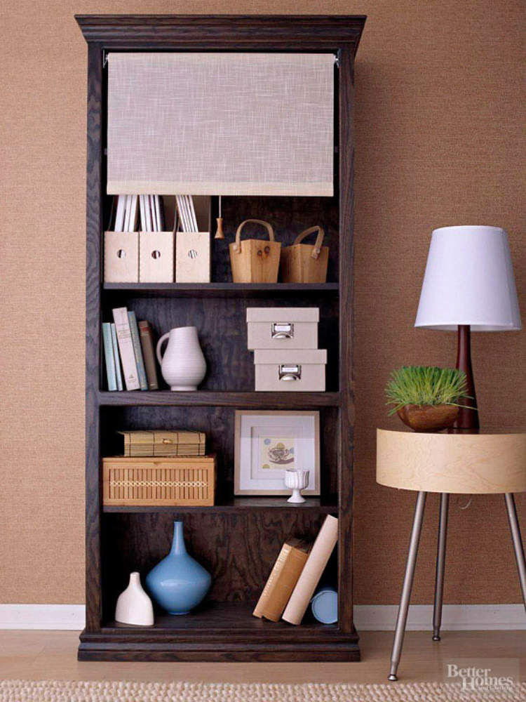 Storage ideas, including a roll down shade hiding clutter on a bookshelf