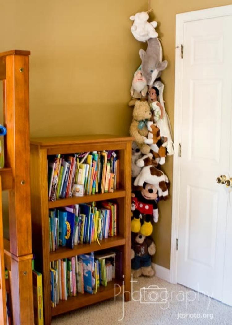 way to organize stuffed animals using a vertical clothesline in the corner of a room and attaching animals with clothespins