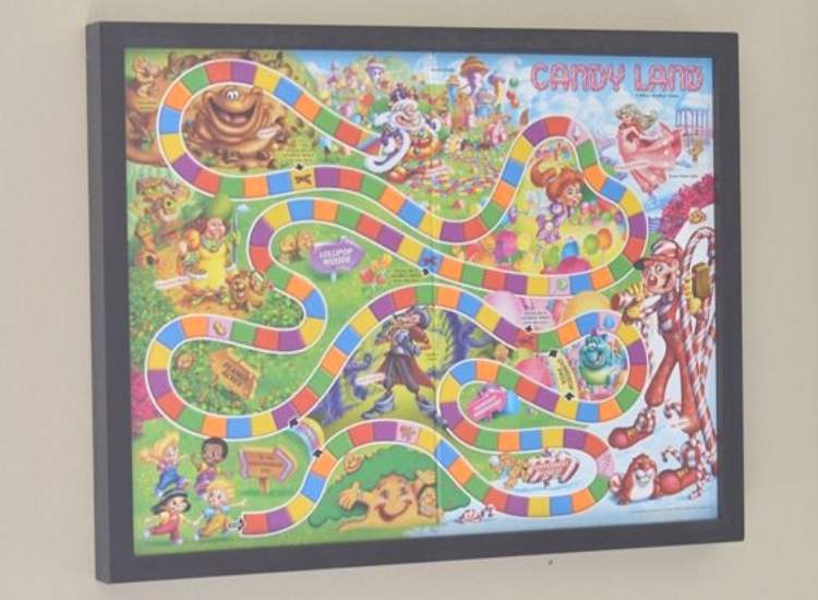 ways to organize toy board games by framing them and hanging them on the wall with a black frame. 