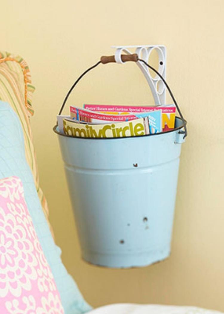 hanging bucket with books and magazines mounted on the wall next to a chair