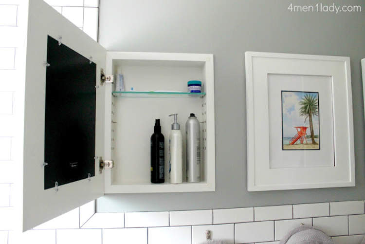 Hidden storage idea for the bathroom - including a built in cabinet concealed by framed art.