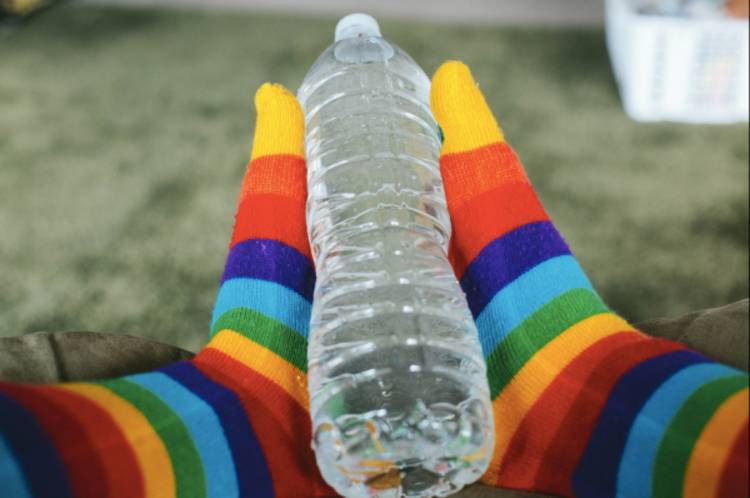 cold-weather-camping image of feet in socks holding a water bottle between them