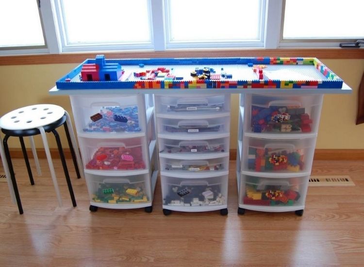 organizing toy legos using a lego table made of clear storage drawer towers with a removable piece of wood on top for building 