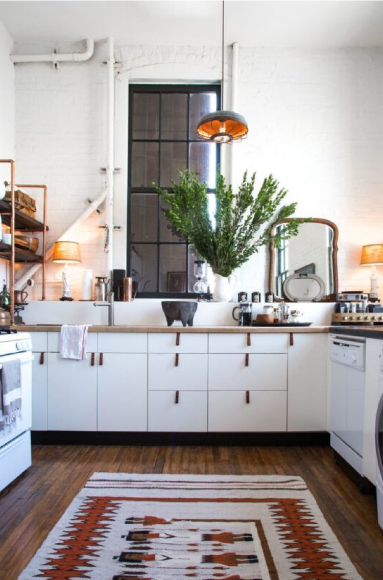 apartment decorating with white kitchen with a rug on the floor and pulls on the cabinets