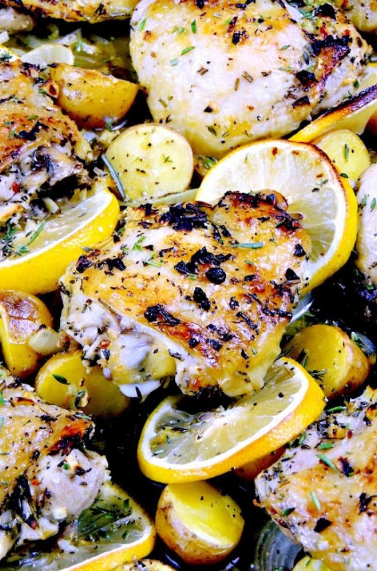 Sheet pan lemon chicken dinner: sliced lemons, chicken, and herbs