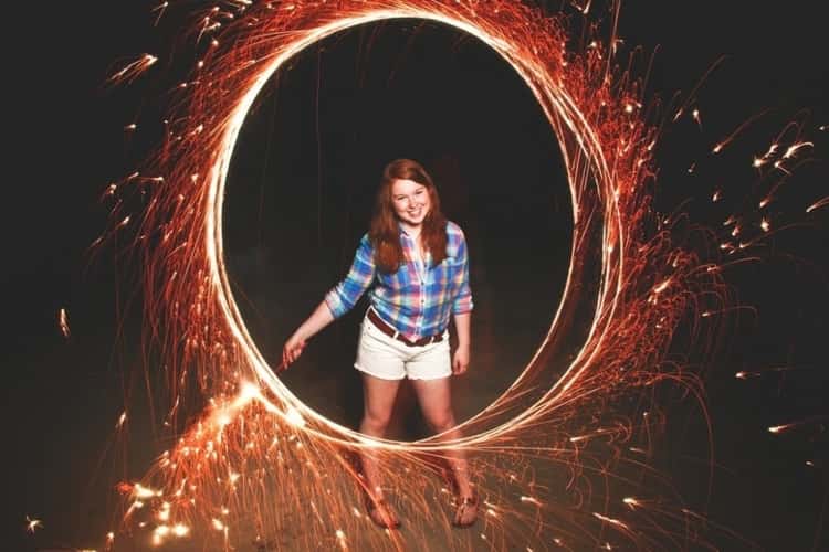 girl holding lit sparkler in the dark