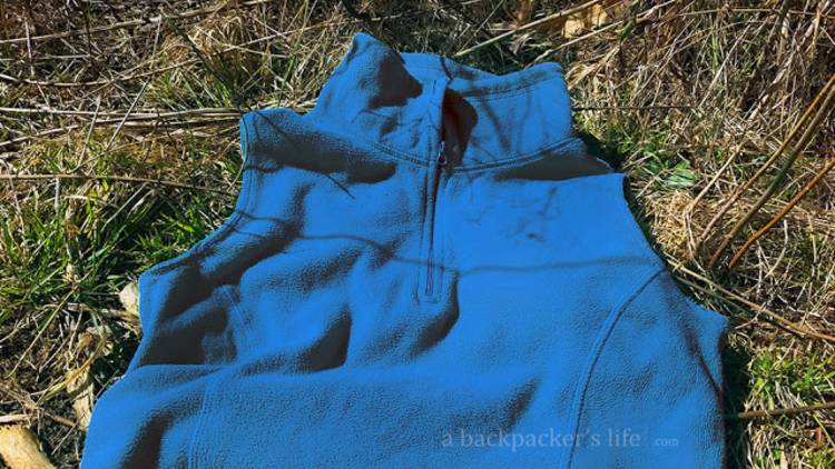 cold-weather-camping image of a fleece vest on the grass